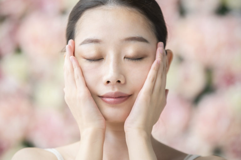 Junge Asiantin mit Glow auf der Haut nach Gesichtsöl
